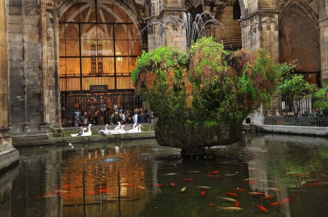 The cloister of Barcelona Cathedral, its garden and pond under the pointed arches